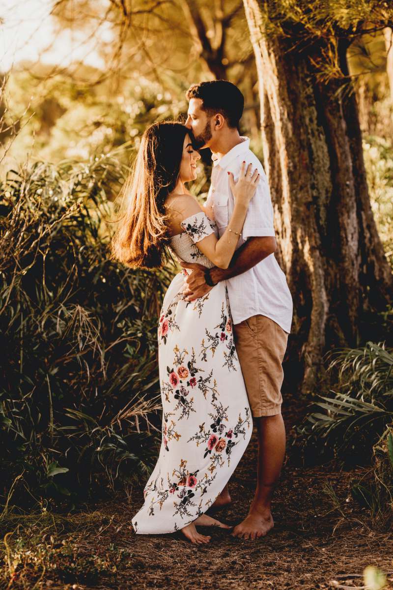 tree man and woman kissing near brown tree during daytime couple